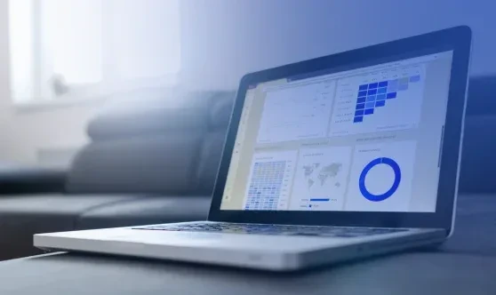 Laptop computer displaying digital financial analytics, data charts, and reporting dashboards on a table