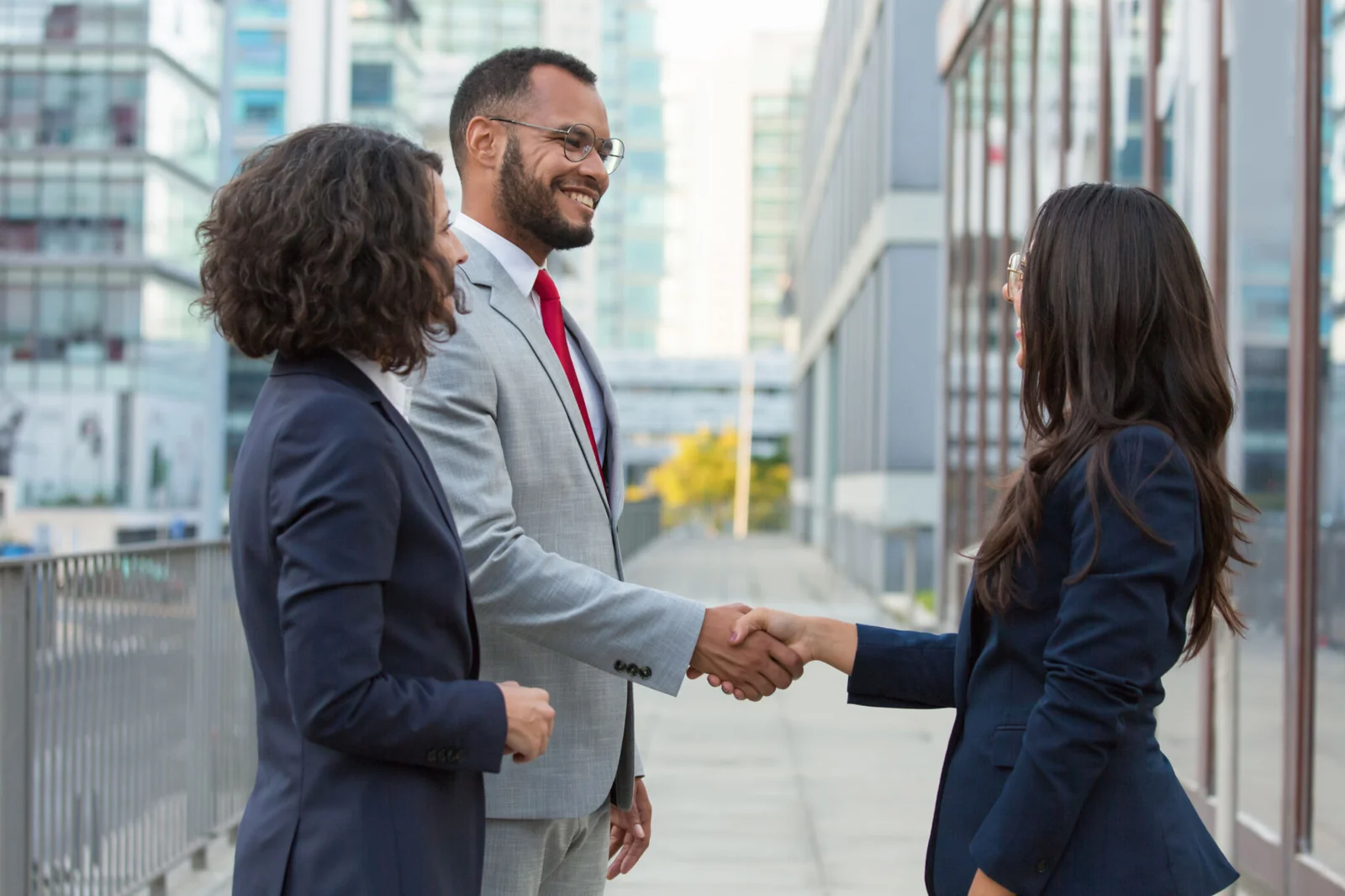 Business professionals shaking hands outdoors in corporate setting
