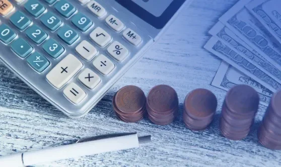 Calculator and coins representing financial calculations and cost control