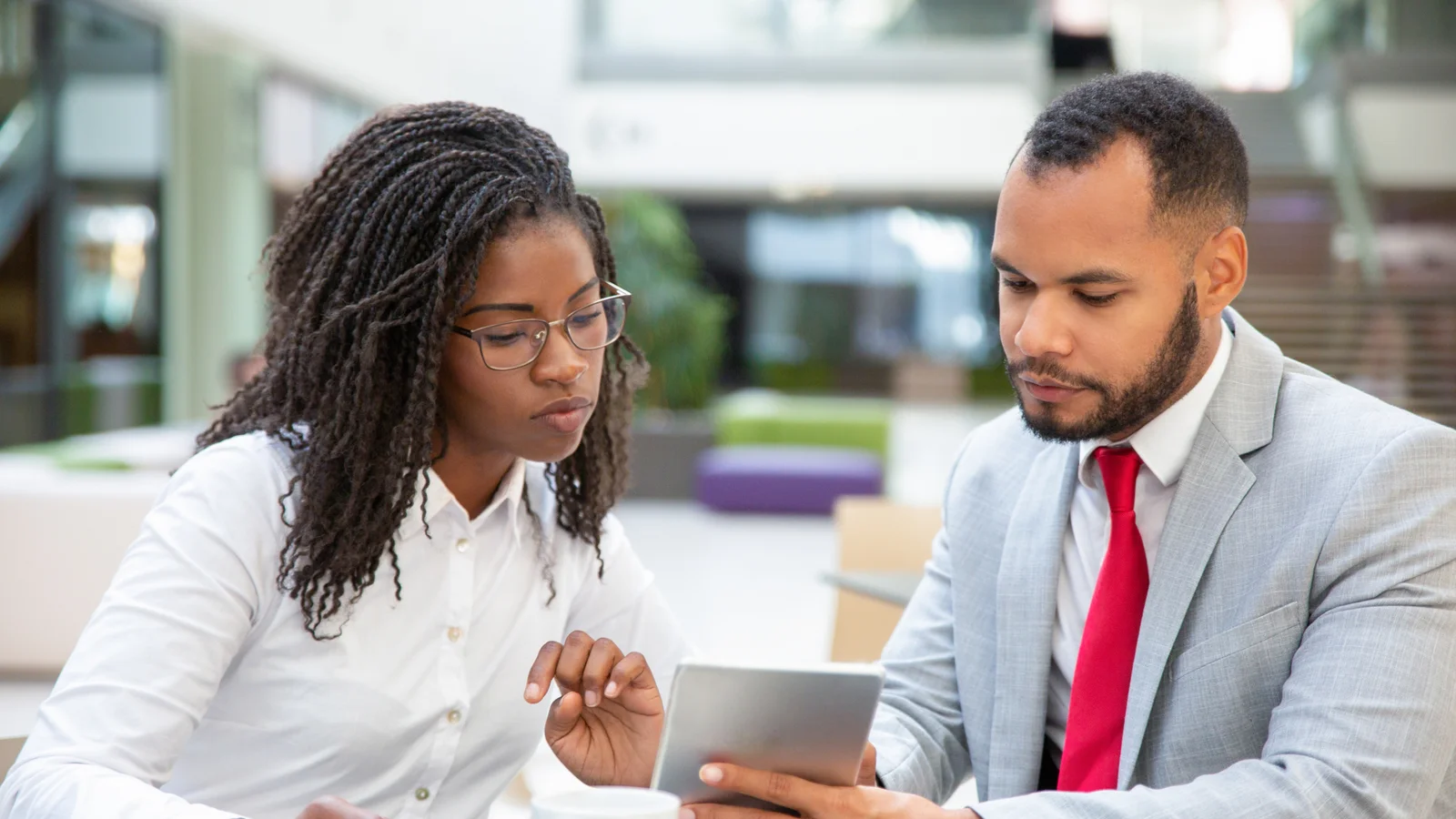 Professionals discussing financial insights using tablet